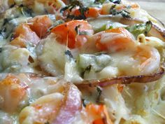 a pizza with shrimp, carrots and cheese on it