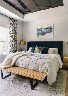 a bedroom with a large bed and wooden bench