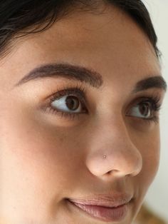 a close up of a woman's face with brown hair and light blue eyes