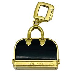 Product details: The charm is designed by Louis Vuitton, it is made out of 18K yellow gold and black enamel. Elegant Black Jewelry With Gold-tone Logo Plaque, Luxury Black Jewelry With Gold-tone Logo Plaque, Luxury Black Jewelry With Gold-tone Logo, Luxury Black Jewelry With Gold-tone Hardware, Vintage Louis Vuitton, Purse Charms, Gold Enamel, Black Enamel, Jewellery And Watches