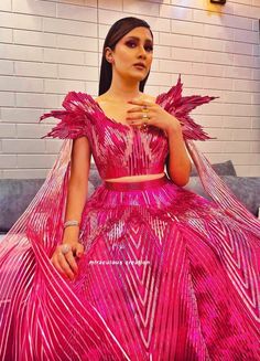 a woman in a pink dress posing for the camera