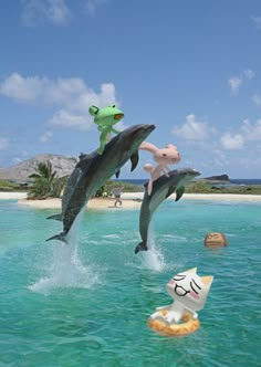 two fake dolphins are jumping out of the water in front of a cat and dog toy