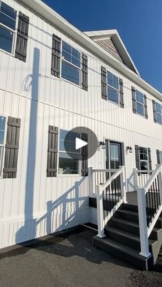 a white house with black shutters and stairs