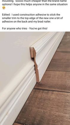 an image of the corner of a wall with wood flooring and white paint on it