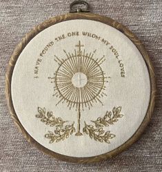 an embroidered compass on a wooden frame