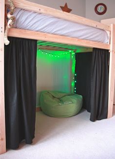 there is a bed with curtains and lights on the bottom bunk, next to an inflatable bean bag chair