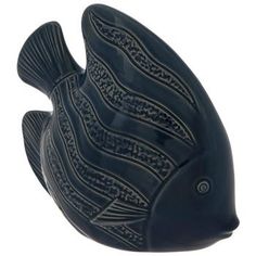 a black fish shaped object sitting on top of a white surface with an intricate design