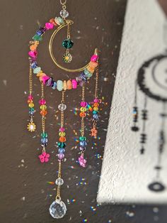 a close up of a wind chime hanging on a wall with beads and crystals