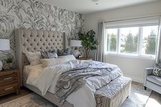 a bedroom with a large bed and two chairs in front of a window that has a palm tree wallpaper on it