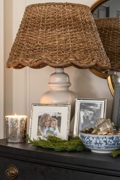 a lamp on top of a dresser next to pictures