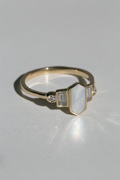 Art deco inspired ring with Mother of Pearl and diamonds. Iridescent Mother of Pearl is inlaid into the elongated hexagon, measuring 9.5mm x 5mm. Accent diamonds are approximately .30 total carat worth, in your choice of natural or lab-grown. Millimeter measurement from end to end is 15mm. Your choice of gold color and karat. The band is 1.75mm thick. Please leave a note at checkout with your preferred size. All gems and rocks are nuanced in color, please know that your ring will be very similar Simple Art Deco Ring, Abalone Engagement Ring, Mother Of Pearl Engagement Ring, Classic Formal Rings With Mother Of Pearl, Wedding Pearl Ring With Mother Of Pearl, Mother Of Pearl Ring, Formal Mother Of Pearl Ring, Gold Mother Of Pearl Ring As A Gift, Elegant Round Mother Of Pearl Ring