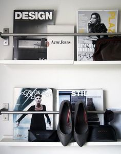 two white shelves with magazines and shoes on them