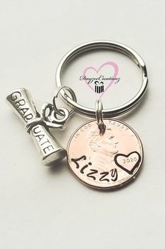 a penny keychain with the word kiss me on it and a cross charm