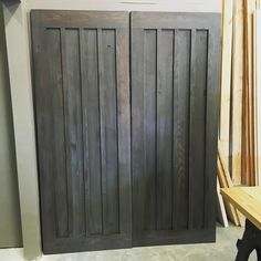 a couple of wooden doors sitting next to each other on top of a table in a room