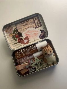 two tins with various items in them on a table