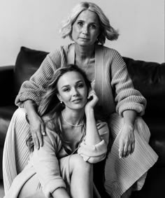 two women sitting on top of a couch next to each other