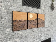 three wooden paintings on the side of a brick wall next to a window with shutters