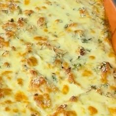 an orange casserole dish filled with cheese and meat