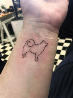 a small dog tattoo on the wrist