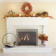 the fireplace is decorated with fall foliage and candles