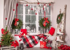 christmas decorations in front of a window with red and white plaid blankets on the windowsill