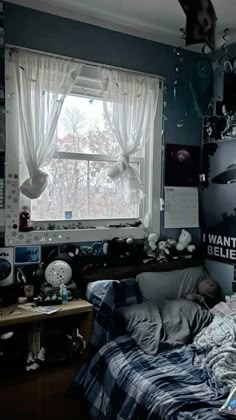 an unmade bed sitting next to a window in a room with pictures on the wall