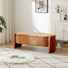 a living room with a white rug and a brown bench in the middle of it