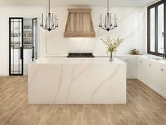 a kitchen with white marble counter tops and wooden flooring that has chandeliers hanging from the ceiling