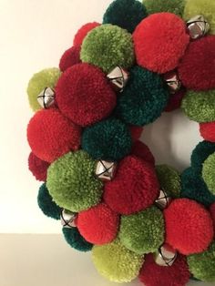 a green and red wreath with bells on it