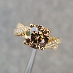 a diamond ring with two rows of diamonds around it on top of a metal stick