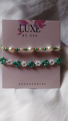 two green and white beaded bracelets on top of a pink card with the name luxe by zei