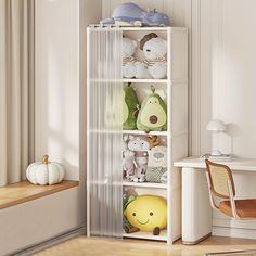 a white shelf filled with stuffed animals next to a desk and chair in a room