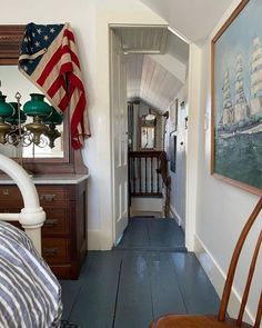 a hallway leading to a bedroom with an american flag hanging on the wall above it