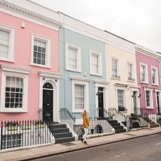 a woman walking down the street in front of row houses