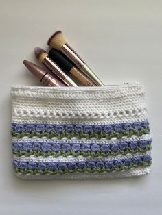 three makeup brushes in a crocheted pouch