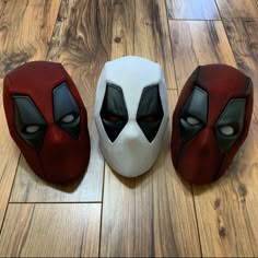 three masks sitting on top of a wooden floor