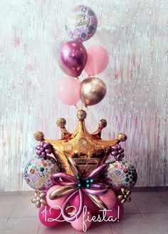 a birthday cake with balloons and a crown on top