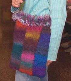 a woman holding a multicolored bag in her hands