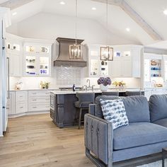 a living room filled with furniture next to a kitchen