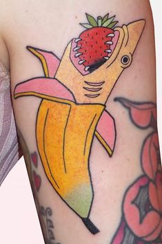 a banana with a strawberry on it and an image of a woman's arm