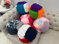 a pile of knitted balls sitting on top of a couch