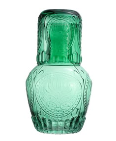 a green glass vase sitting on top of a table