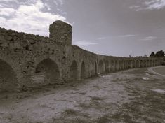 an old stone wall with arches on the side