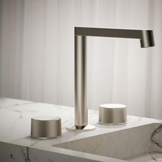 a modern sink and faucet in a white marble countertop with an ice bucket