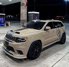 a beige jeep parked in front of a gas station