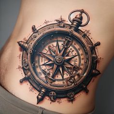 a man's stomach with a compass tattoo on his side and an anchor in the middle