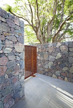 an outdoor area with stone walls and wooden slats on the sides, surrounded by trees