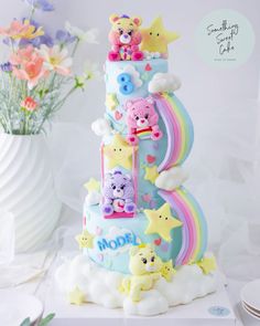 there is a multi layer cake decorated with teddy bears and rainbows on the top