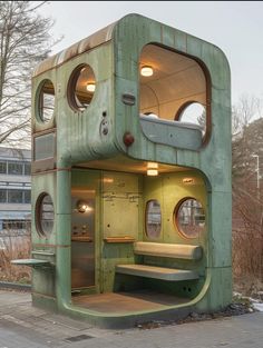 an unusual looking green building with lots of windows