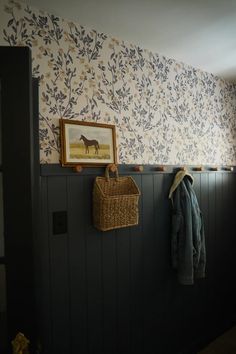 the coat rack is hanging on the wall next to the coat rack with a basket